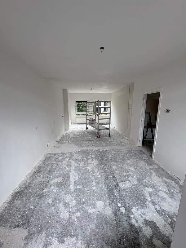 Lege woonkamer met strak gestucte witte wanden en plafond